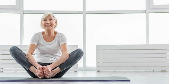 Eine ältere Dame trainiert in einer Turnhalle
